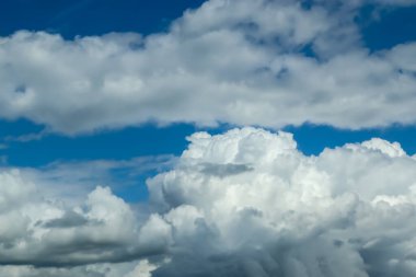 Güzel pofuduk beyaz bulut oluşumları Derin mavi bir yaz gökyüzünde