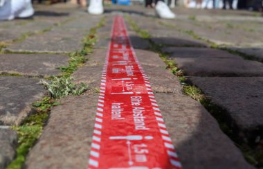 Bitte Abstand Halten! COVID-19 için 1,5 metre sosyal uzaklık işareti. Uzaklık sembolünü Almanca 'da tut