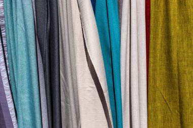 Kumaş pazarında bulunan kumaş ve kumaş örneklerine farklı renklerde yakından bakmak.