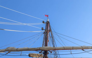 Mavi gökyüzüne karşı yelkenli gemi direği ile yelkenli teknelerinde yelken açmak.