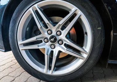 Kiel, Almanya - 08. Eylül 2025: Ford Mustang logosuna sahip parlak alüminyum halka, lastik ve fren diski ayrıntılarını gösteriyor