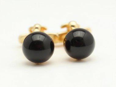 Siyah akik küreli altın kol düğmeleri sofistike ve tarzı sembolize eder, herhangi bir resmi kıyafete biraz klas katar.