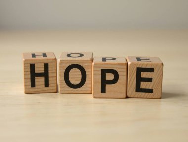 Siyah harfli dört tahta küp, açık tahta bir masada 