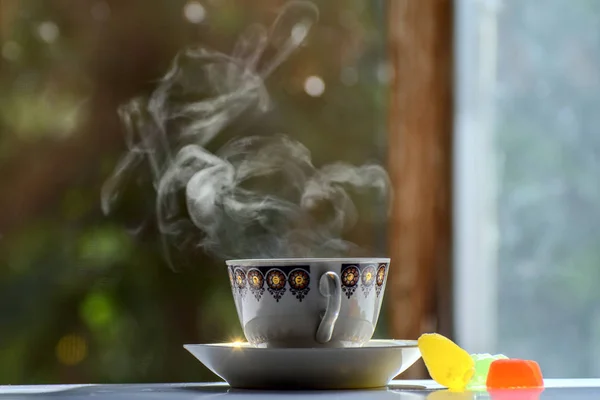 bir fincan çay çay yeşil bir arka plan üzerinde içinde taze buhar ile. Marmelat renkli dilim