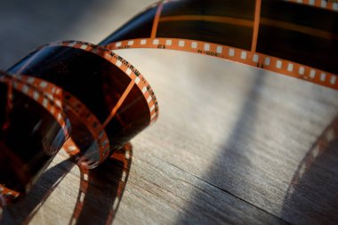 35 mm film ahşap arka plan üzerinde yuvarlandı.