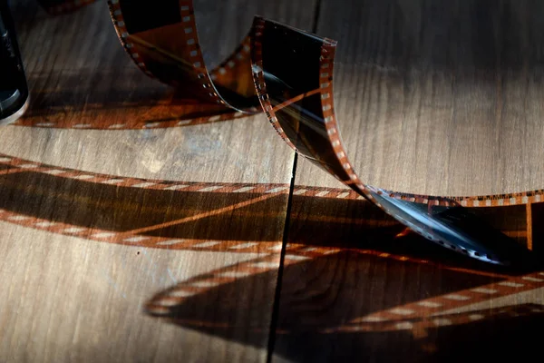 35 mm rolled film on wooden background