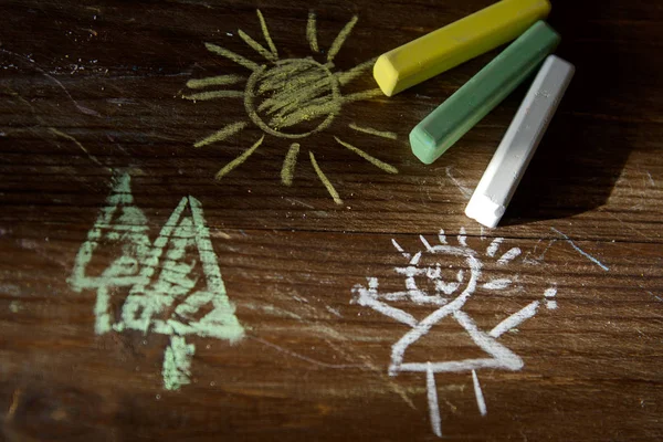 Children's drawing and color crayons illuminated by the sun