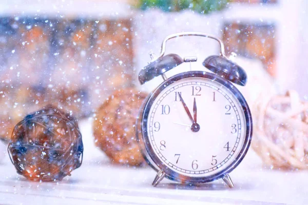 Vintage clock on the background of the balls. Snowing