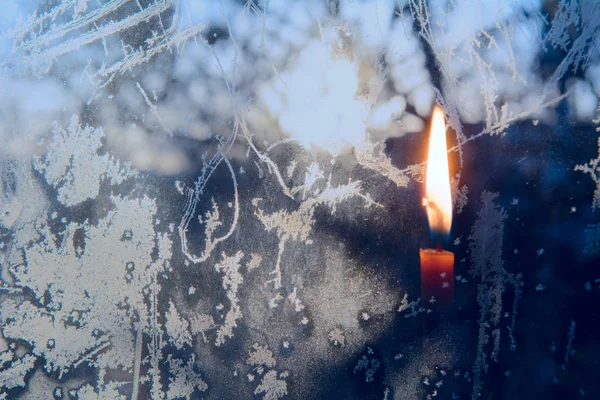 蜡烛在冰冷的窗户上燃烧着 — 图库照片