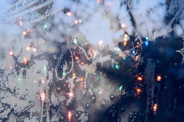 Weihnachtsbeleuchtung Auf Dem Hintergrund Eines Frostigen Fensters — Stockfoto