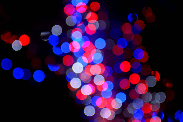 On a dark background multi-colored Christmas lights