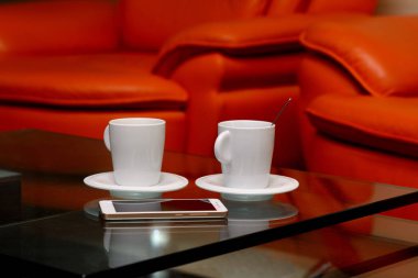 cam üzerine bir fincan kahve ve bir beyaz smartphone tablodur