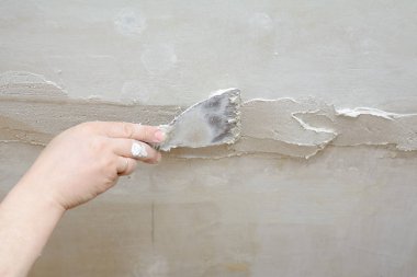 Erkek el mala tutar, tavandaki çatlakları kapatarak.