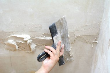 Erkek el mala tutar, tavandaki çatlakları kapatarak.