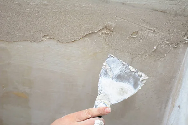 Erkek el mala tutar, tavandaki çatlakları kapatarak.