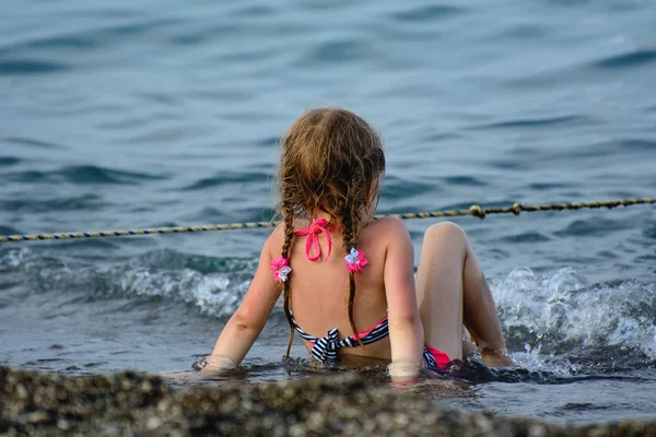 Girl Pigtails Sits Seashore Wave Rushes Her Legs Concept Happy — Stock Photo, Image