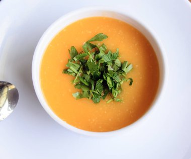 maydanoz ile beyaz bir tabakta mercimek çorbası. Üstte görüntü