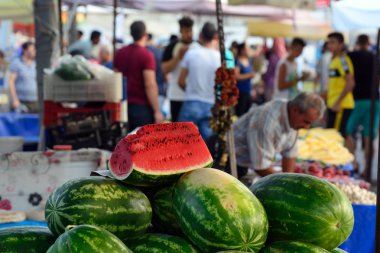 Doğu çarşısının tezgâhında karpuzlar. Etrafta alıcılar var. Doğal ışık. Kavram - Kültürel Çeşitlilik