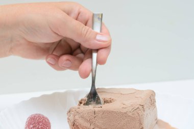 Beyaz bir tabakta kahvedondurma ve iki marmelat vardır. Bir kadın elinde bir çay kaşığı. Bir kadın dondurma denemeye çalışıyor. Konser - tatlı