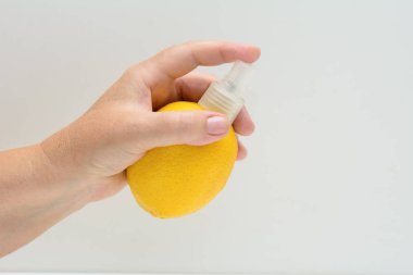 Bir kadın elinde, sprey şapkalı bir iblis. Konsept - limon meyve tazelik. Spreyi. Limon kokusu.