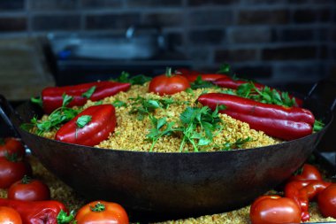 Dökme demir tavada, kırmızı biber, domates, otlar, maydanoz ile süslenmiş pilav. Konsept bir tatil yemeği. Tatil yemeği. Asya mutfağı