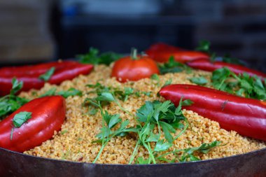 Dökme demir tavada, kırmızı biber, domates, otlar, maydanoz ile süslenmiş pilav. Konsept bir tatil yemeği. Tatil yemeği. Asya mutfağı