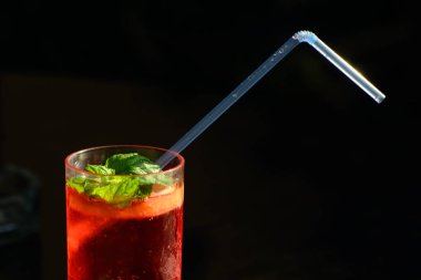 Bir kokteyl ve nane yaprakları ile sisli cam masanın kenarında yer. Kokteylin içinde saman var. Konsept dinlenmek. rahatlama keyfi