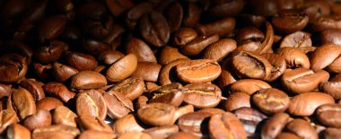 kahve taneleri güneş tarafından aydınlatılmış. Panoramik çekim. Konsept - sabah kahvesi. İyi kahve keyfi