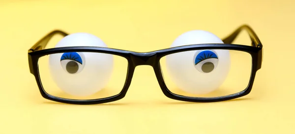 Moldura Preta Óculos Fundo Amarelo Atrás Dos Óculos Estão Bolas — Fotografia de Stock