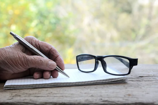 Una Anciana Sostiene Bolígrafo Escribe Cuaderno Muy Cerca Están Las —  Fotos de Stock