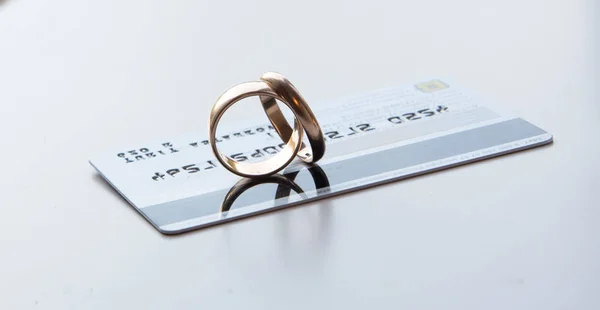 Twee Trouwringen Staan Een Bankkaart Witte Achtergrond Concept Een Huwelijksgeschenk — Stockfoto