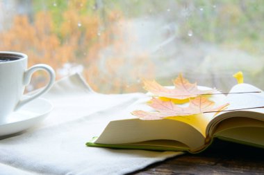 Sade kahve ve birkaç açık kitap. Akçaağaç yaprakları sayfada. Konsept - eğitim, kahve molası, sonbahar günü