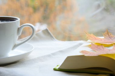 Sade kahve ve birkaç açık kitap. Akçaağaç yaprakları sayfada. Konsept - eğitim, kahve molası, sonbahar günü