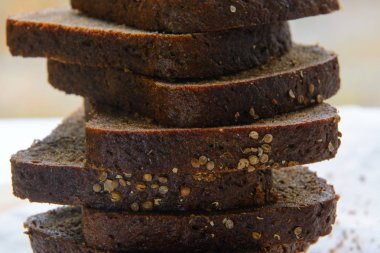 Bir somun siyah ekmek parçalara ayrılmış ve kişniş serpiştirilmiş. Kavram - sağlıklı doğal gıda, diyet