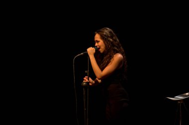 20 yıl yaşlı esmer güzel kız siyah şarkı giyinmiş.