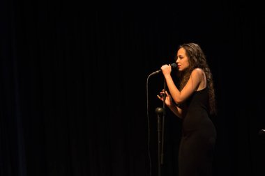 20 yıl yaşlı esmer güzel kız siyah şarkı giyinmiş.