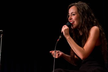 20 yıl yaşlı esmer güzel kız siyah şarkı giyinmiş.