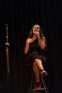 20 yıl yaşlı esmer güzel kız siyah şarkı giyinmiş.