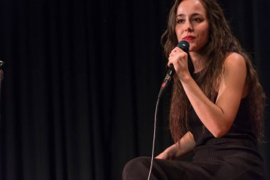 20 yıl yaşlı esmer güzel kız siyah şarkı giyinmiş.