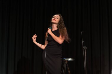 20 yıl yaşlı esmer güzel kız siyah şarkı giyinmiş.