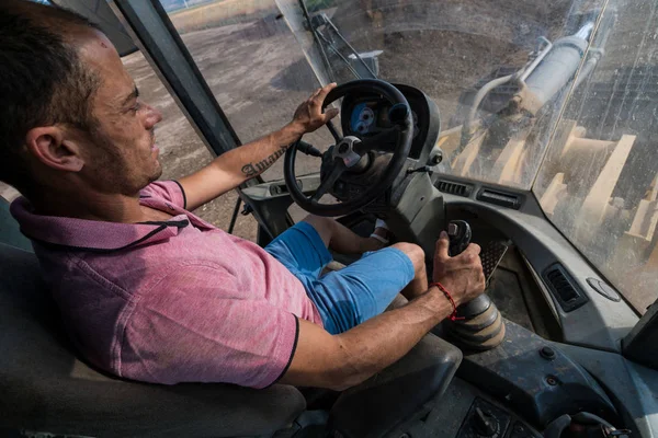 güneşli bir günde çalışan tekerlekli yükleyici operatörü