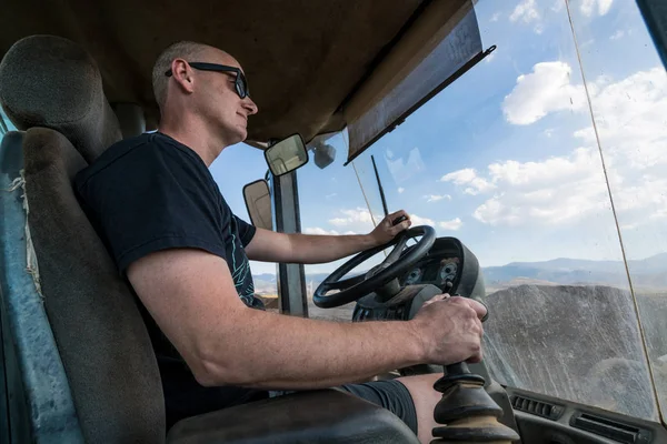 wheel loaders operator with sunglasses working hard in a sunny day