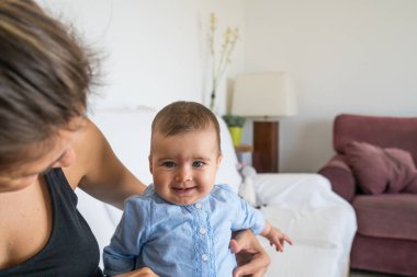 7 aylık mutlu ve gülümseyen bebek, annesiyle oynuyor.