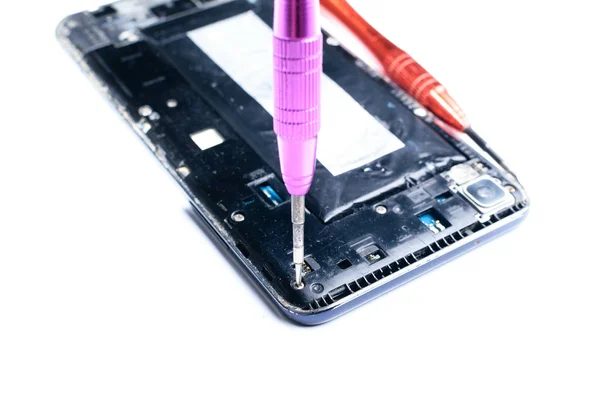 mobil ekipman ve cep telefonlarının onarımı için laboratuvarda bir tornavida ile kırık bir cep telefonu tamir sürecini gösteren yakın çekim fotoğraflar