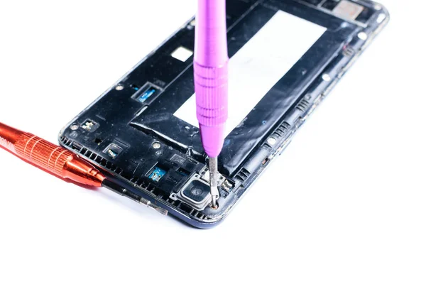 mobil ekipman ve cep telefonlarının onarımı için laboratuvarda bir tornavida ile kırık bir cep telefonu tamir sürecini gösteren yakın çekim fotoğraflar