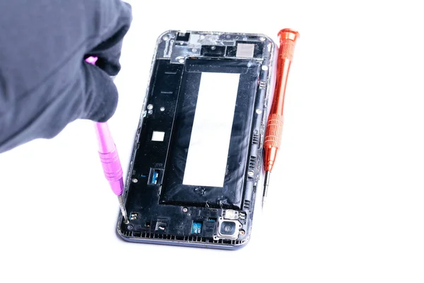 mobil ekipman ve cep telefonlarının onarımı için laboratuvarda bir tornavida ile kırık bir cep telefonu tamir sürecini gösteren yakın çekim fotoğraflar