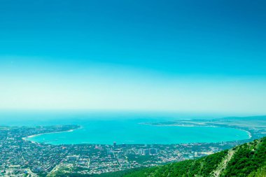 karadenizüzerinde kayalar, mavi gökyüzü ve Kafkas dağları ile deniz manzarası