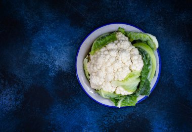 Karnabahar ve su damlaları birbirine zıt dokulu mavi arka planda