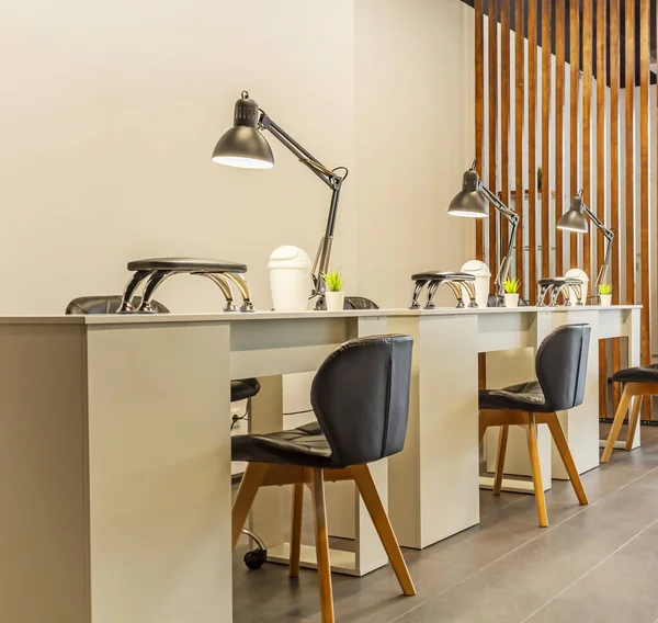 Manicure tables with lamps and cozy chairs in the barbershop