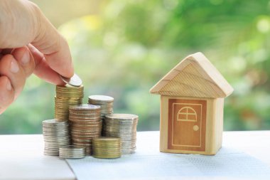 Banka hesabına kitap tasarruf para Emlak merdiven, ipotek ve gayrimenkul yatırım için para kavramı kavramının önünde sikke yığını. kaydetme veya bir ev için yatırım emeklilik